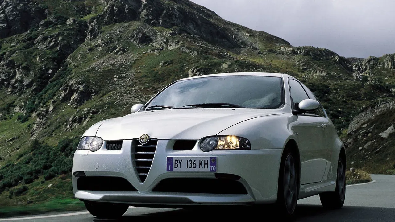 White Alfa Romeo 147 GTA driving on a mountain road