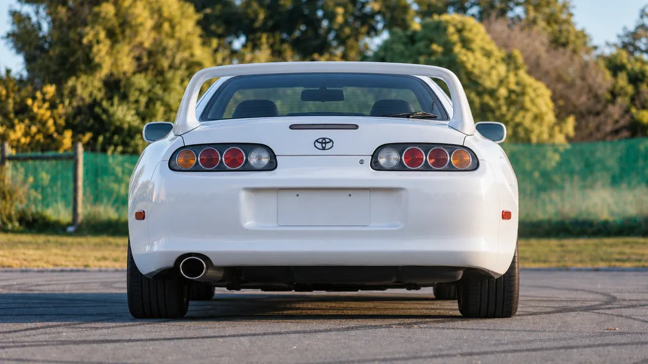 Straight rear view of a stock white Toyota Supra A80